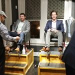 Shoe shiners shining guests' shoes at an event.