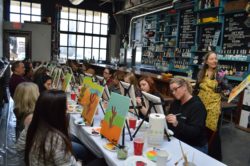guests painting at a paint night hosted at bar